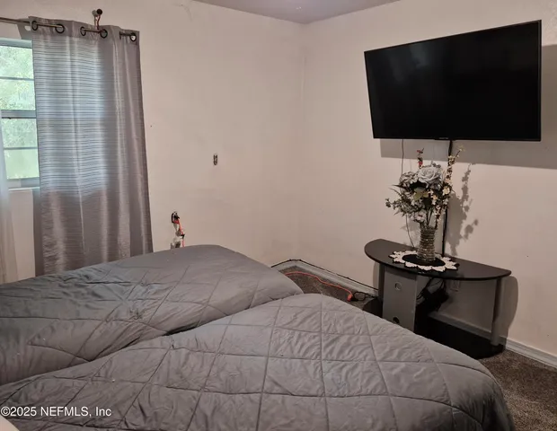 a bedroom with a bed and a flat screen tv
