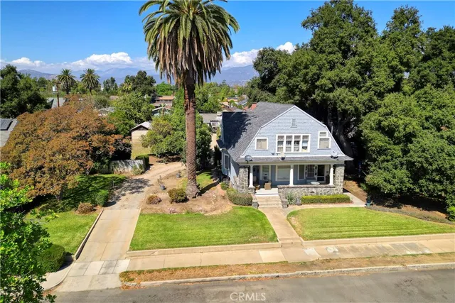a front view of a house with garden and trees