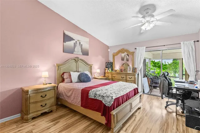 a bedroom with a bed a large window with table and chairs