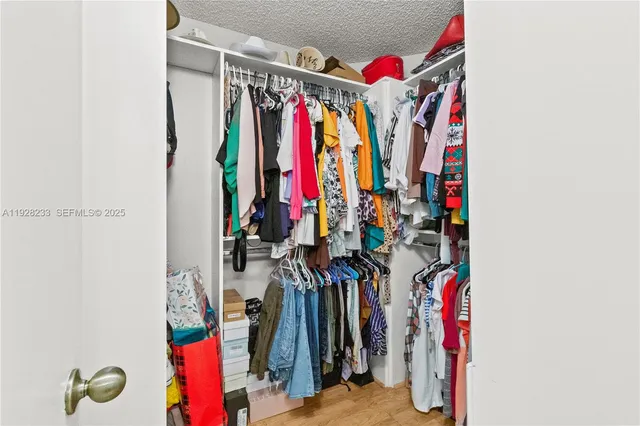 a view of walk in closet with clothes