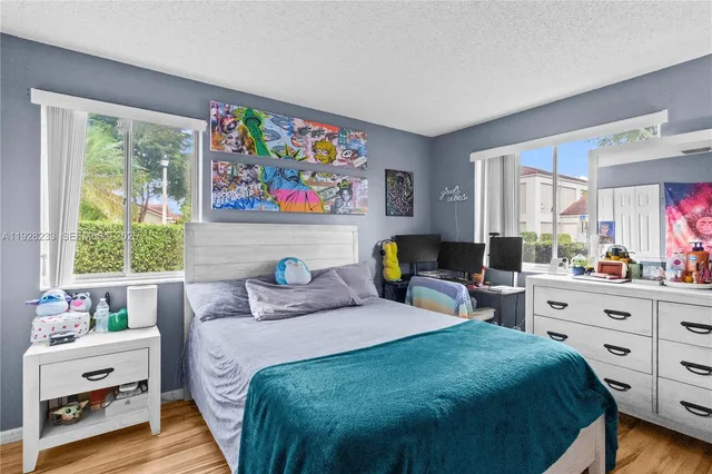 a bedroom with a bed and a dresser next to a window