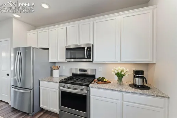 a view of a room with wooden floor chandelier and entryway