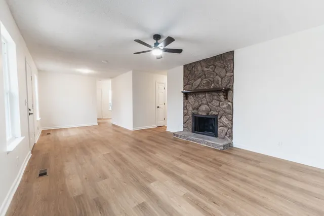 a view of an empty room with a fireplace and a window