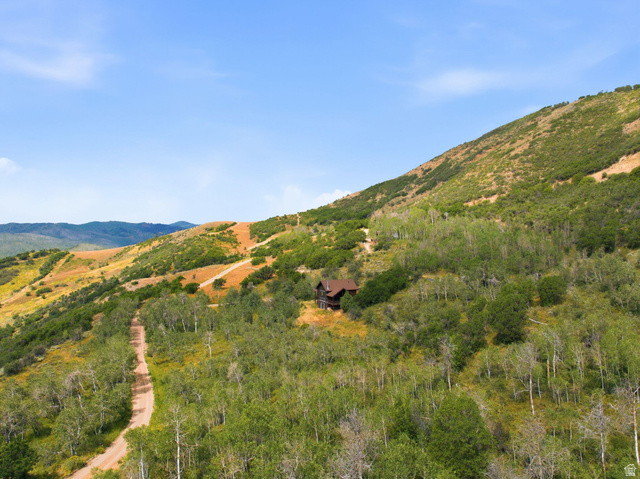 5404 Mountain View Road Coalville, UT 84017 - Photo 43 of 50 Mountainous terrain with natural landscaping, a winding dirt road, and a single-family residence featuring a brown exterior
