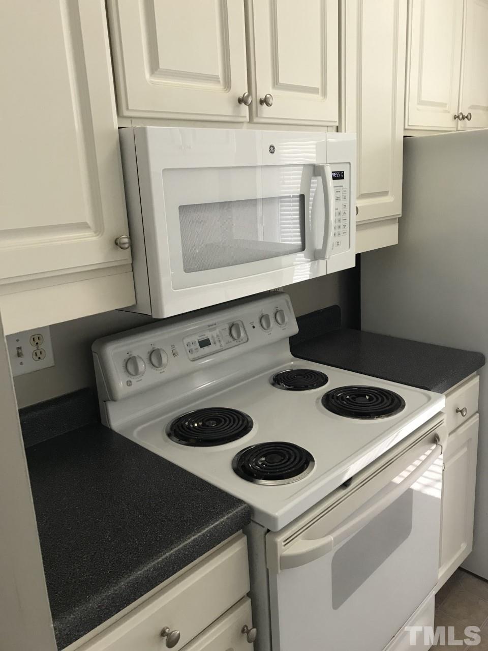 1701 Tiffany Bay Court, Unit 102 Raleigh, NC 27609 - Photo 6 of 13 a stove top oven sitting inside of a kitchen