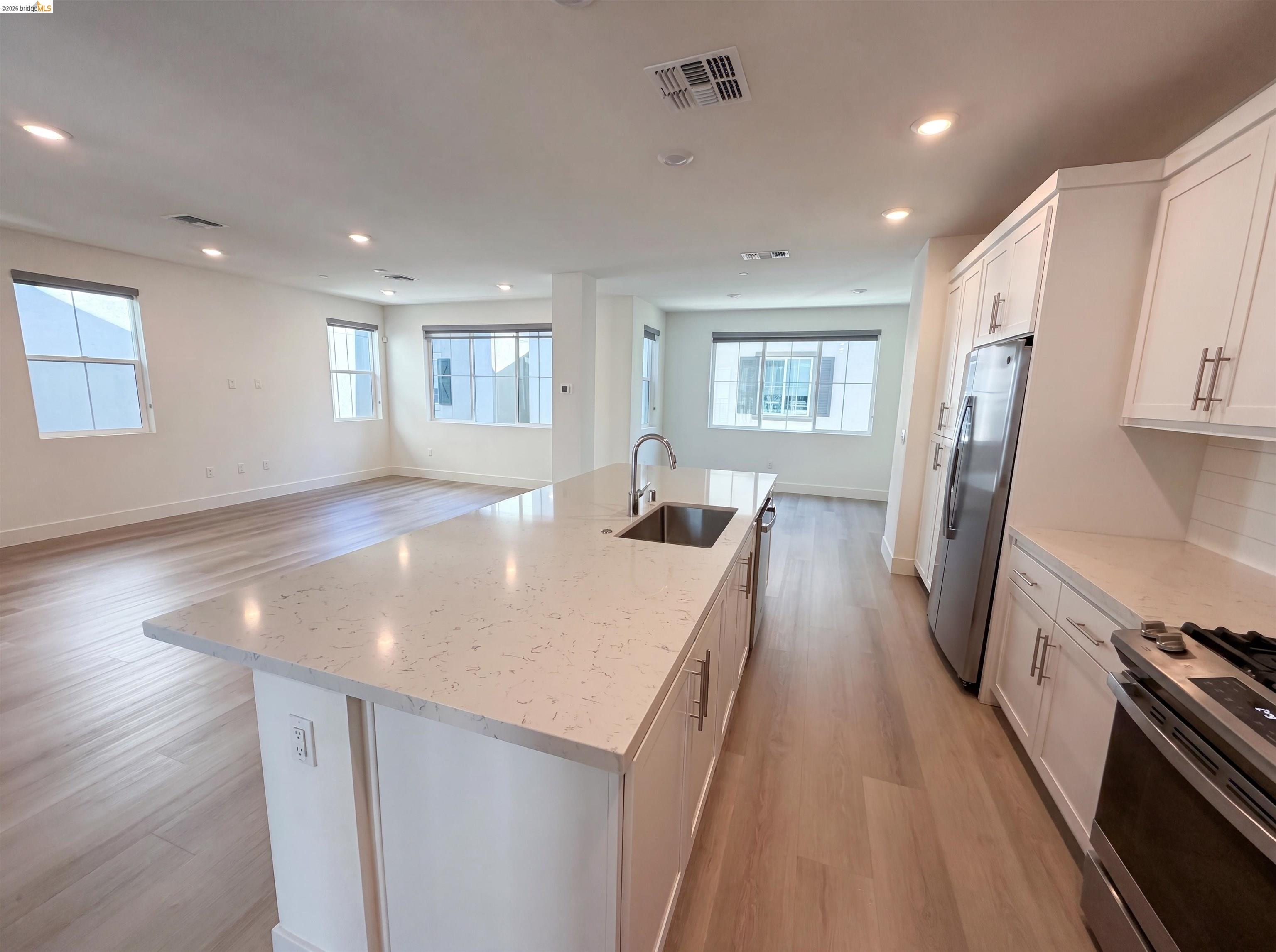 9034 Rudder Way Newark, CA 94560 - Photo 33 of 38 Modern kitchen island featuring a stainless steel sink and a light-toned countertop