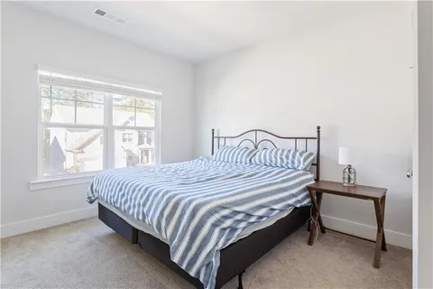 a bed sitting in a bedroom next to a window