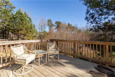 a view of a balcony with chairs and wooden fence