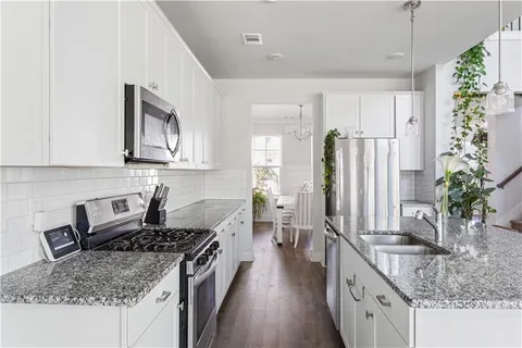 a kitchen with stainless steel appliances granite countertop a sink stove and refrigerator