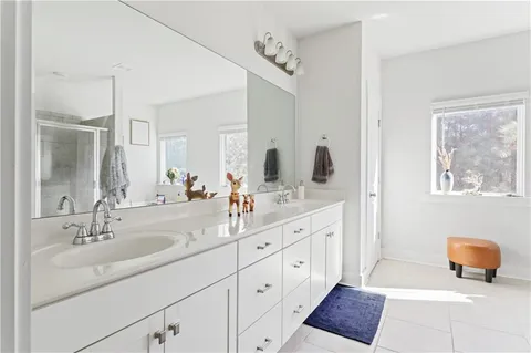 a bathroom with a double vanity sink mirror and bathtub