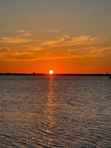 a living room with furniture a fireplace and a dining table with wooden floor