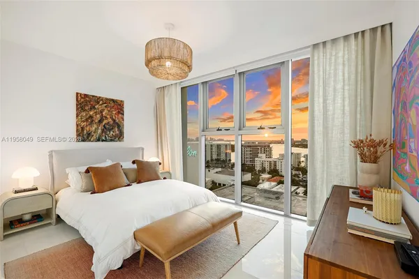 a bedroom with a bed and a large window