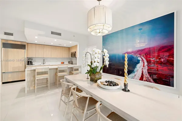 a kitchen with stainless steel appliances a table and chairs in it