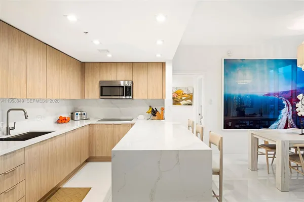 a kitchen with furniture a sink a counter top space stainless steel appliances and cabinets