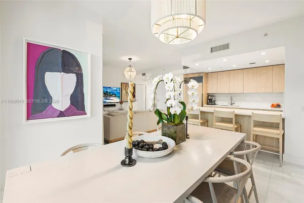 a view of a dining room with furniture a kitchen and chandelier