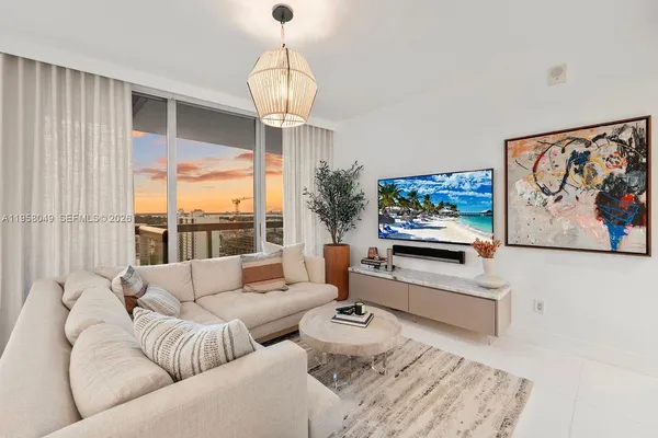 a living room with furniture a flat screen tv and a large window