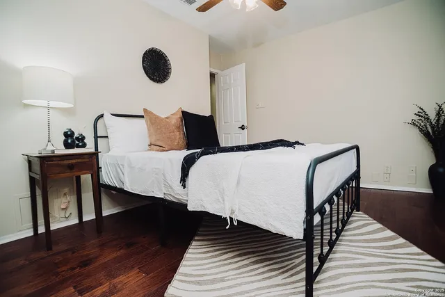 a bedroom with bed and wooden floor