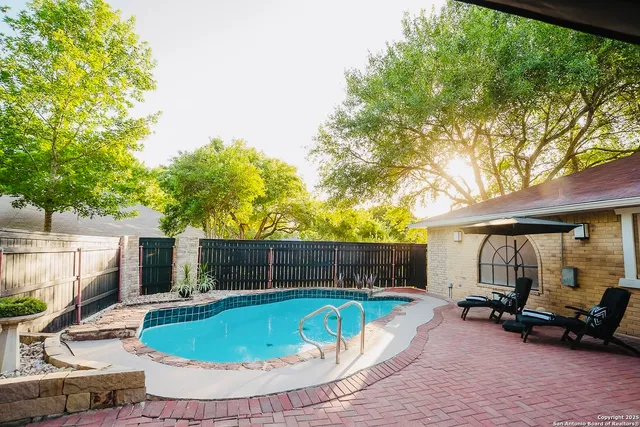 a view of house with swimming pool and sitting area