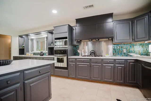 a kitchen with stainless steel appliances a sink stove and refrigerator