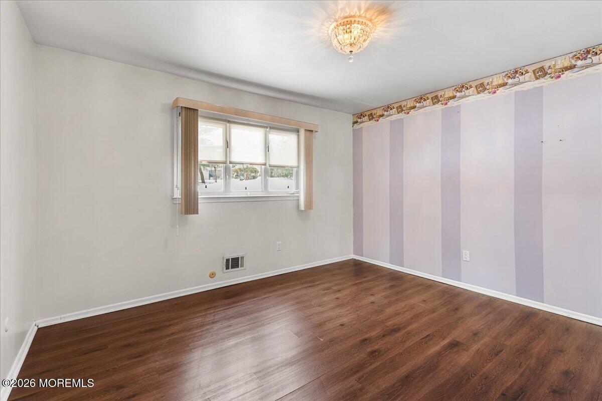 323 Arlene Terrace Aberdeen, NJ 07747 - Photo 19 of 28 a view of an empty room with wooden floor and a window