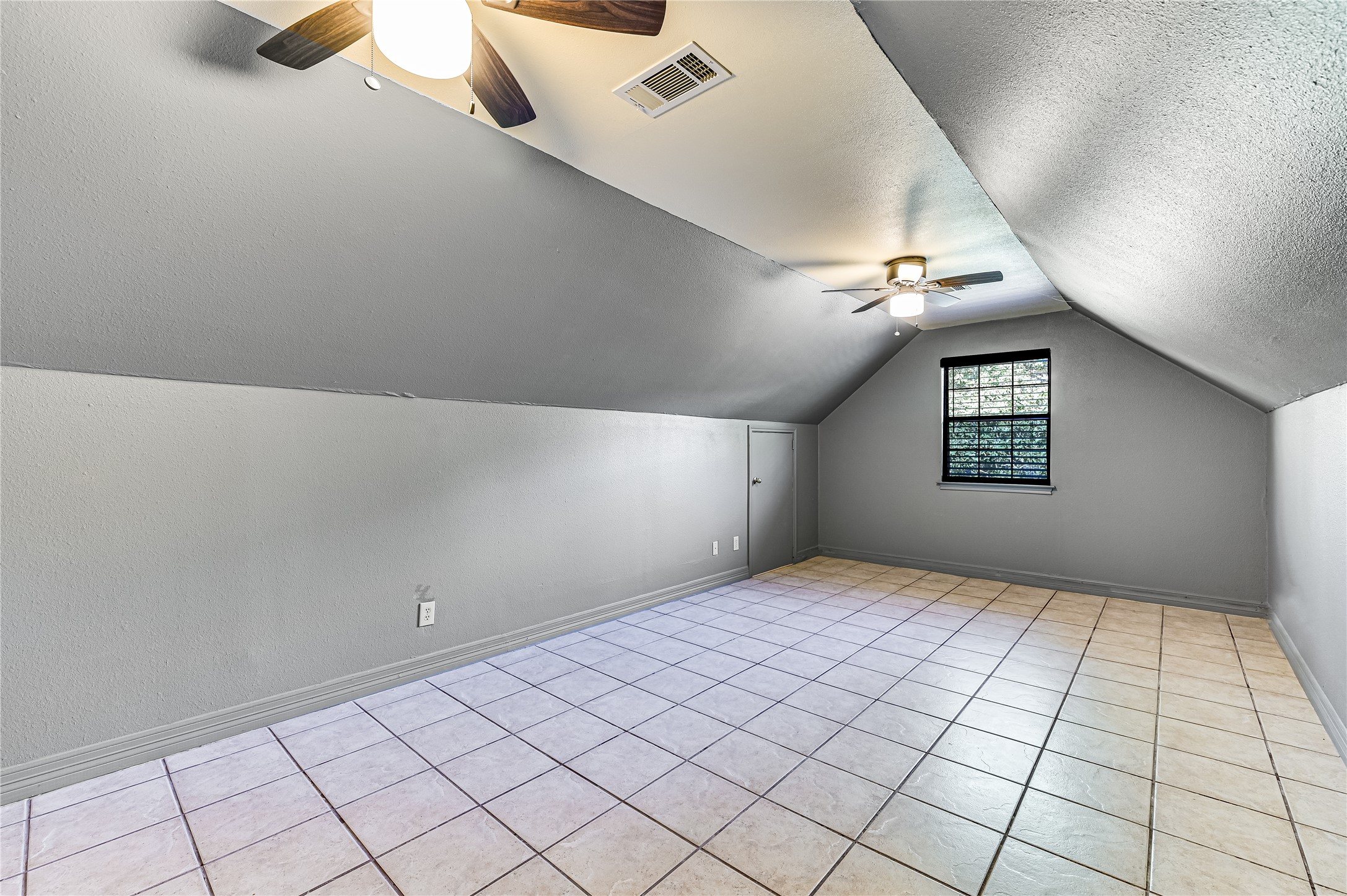 486 Westwood Road Lockhart, TX 78644 - Photo 13 of 29 Bonus room with a ceiling fan, vaulted ceiling, a textured ceiling, and light tile floors & closets