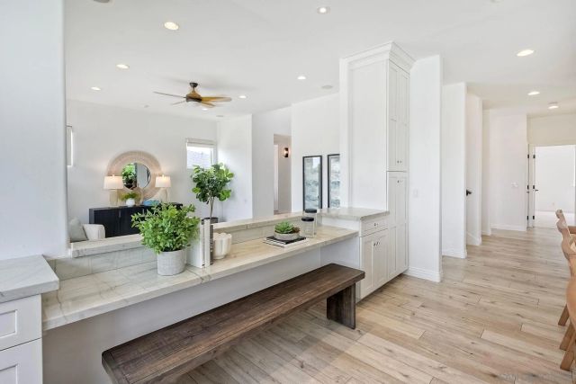 a kitchen with stainless steel appliances kitchen island granite countertop a table chairs sink and cabinets