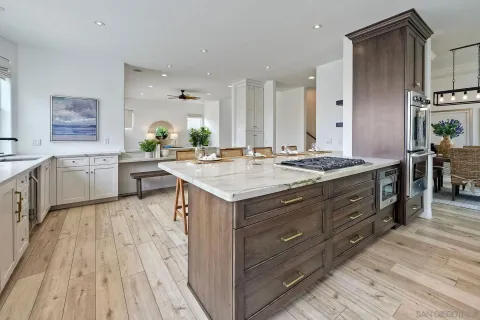 a kitchen with stainless steel appliances white cabinets and wooden floor