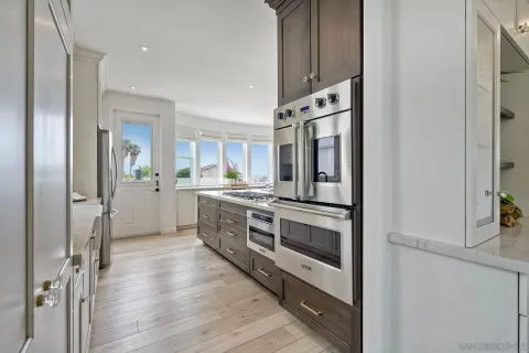 a kitchen with white cabinets and a window
