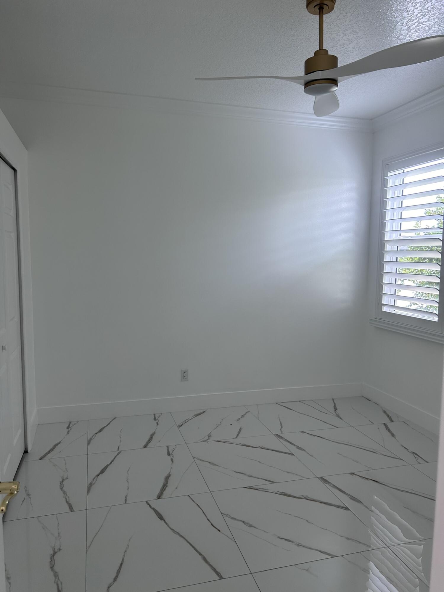 3158 Southwest Martin Street Port St. Lucie, FL 34953 - Photo 11 of 26 an empty room with a ceiling fan and window