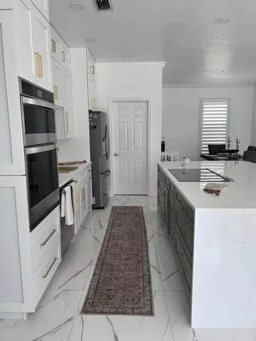 a kitchen with stainless steel appliances a dining table chairs microwave and sink