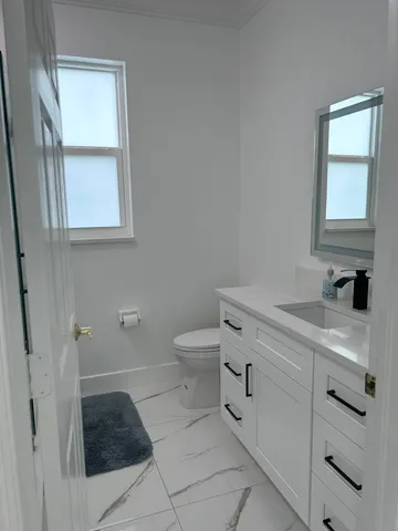 a spacious bathroom with a granite countertop toilet and a shower
