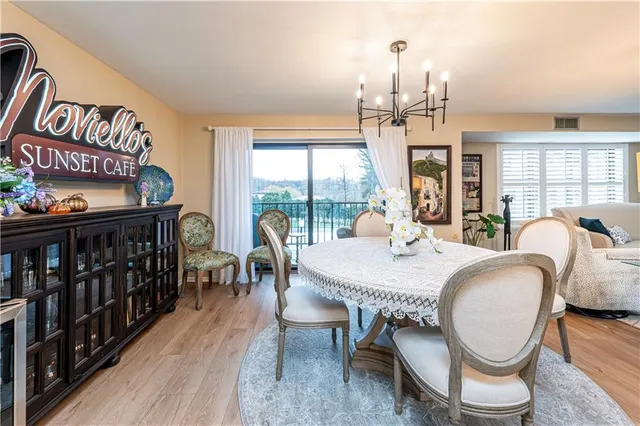 a dining room with furniture a chandelier and wooden floor