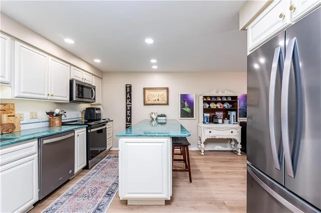 a kitchen with stainless steel appliances granite countertop a refrigerator stove top oven and sink