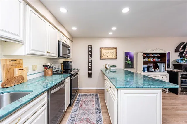 a kitchen with stainless steel appliances granite countertop a sink a stove and a refrigerator