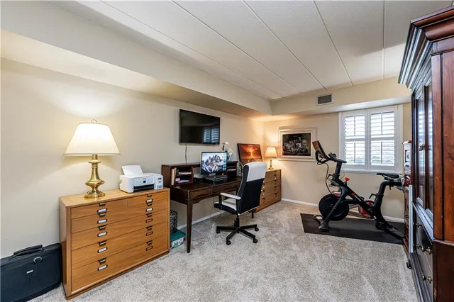 a view of a workspace with furniture and a window