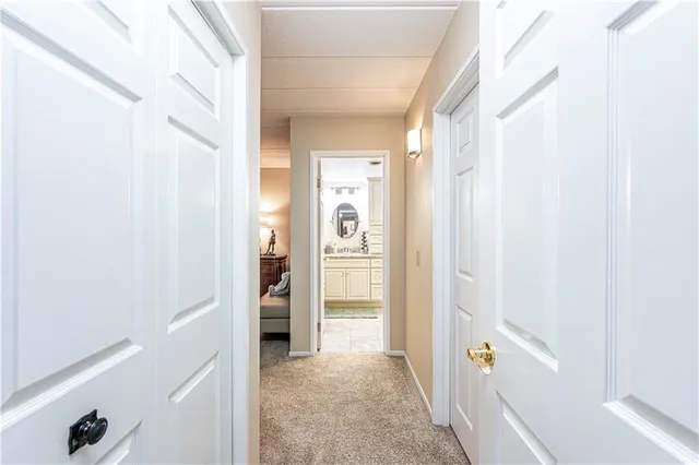 a view of a hallway with bathroom and front door