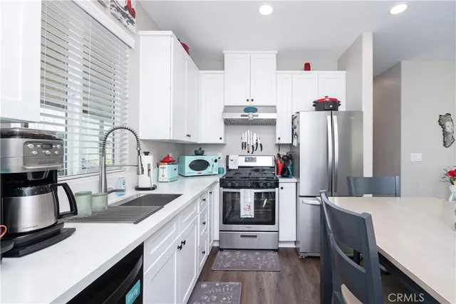 a kitchen with granite countertop white cabinets and white appliances