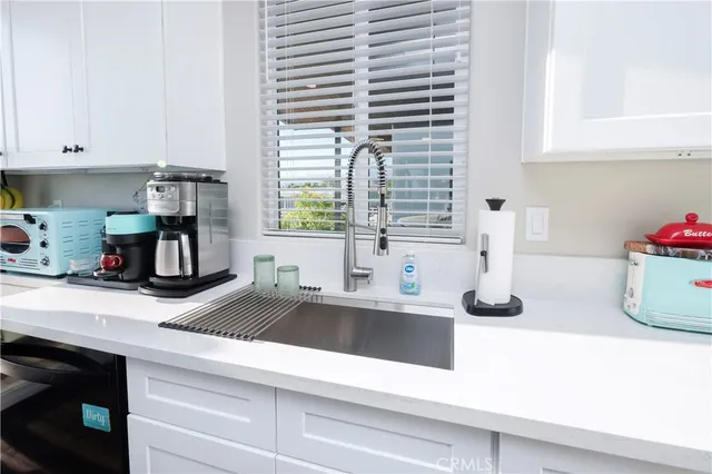 a kitchen with a table chairs sink and cabinets