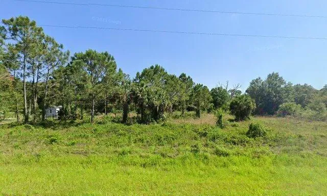 a backyard of a house with trees in the background