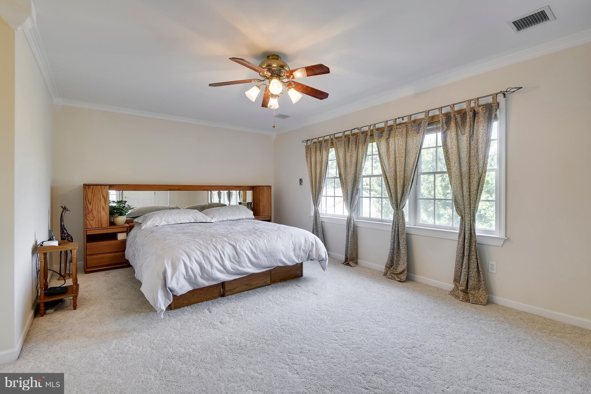122 Cedar Road Chester, MD 21619 - Photo 13 of 28 a bedroom with a large bed and a chandelier