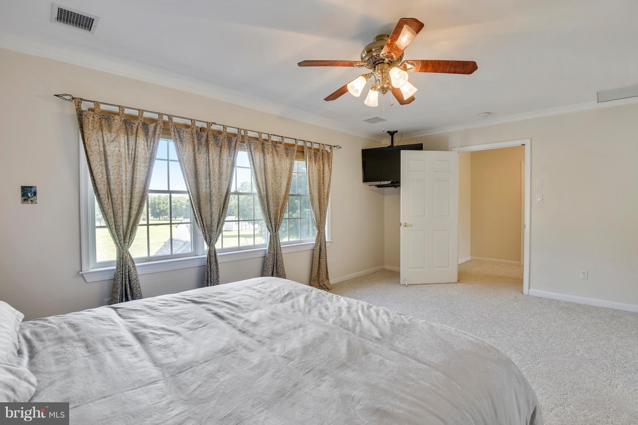 122 Cedar Road Chester, MD 21619 - Photo 14 of 28 a bedroom with a large bed and a chandelier