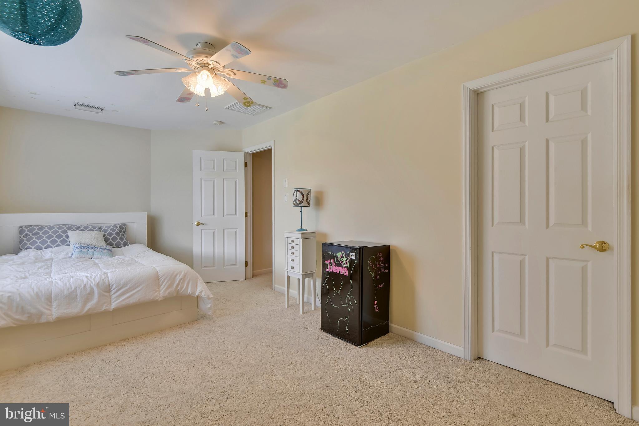 122 Cedar Road Chester, MD 21619 - Photo 21 of 28 a spacious bedroom with a bed and a chandelier
