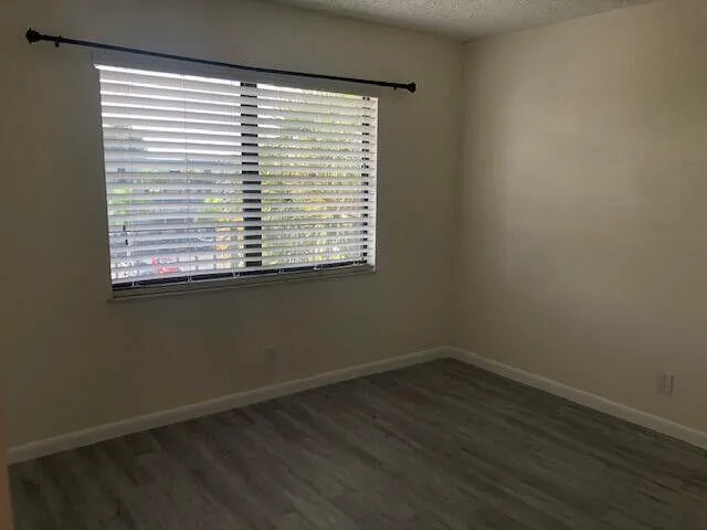 an empty room with wooden floor and a window