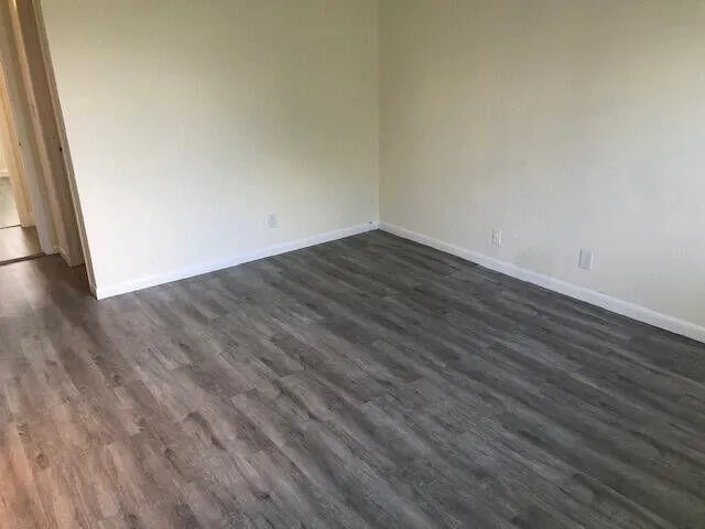 a view of a room with wooden floor