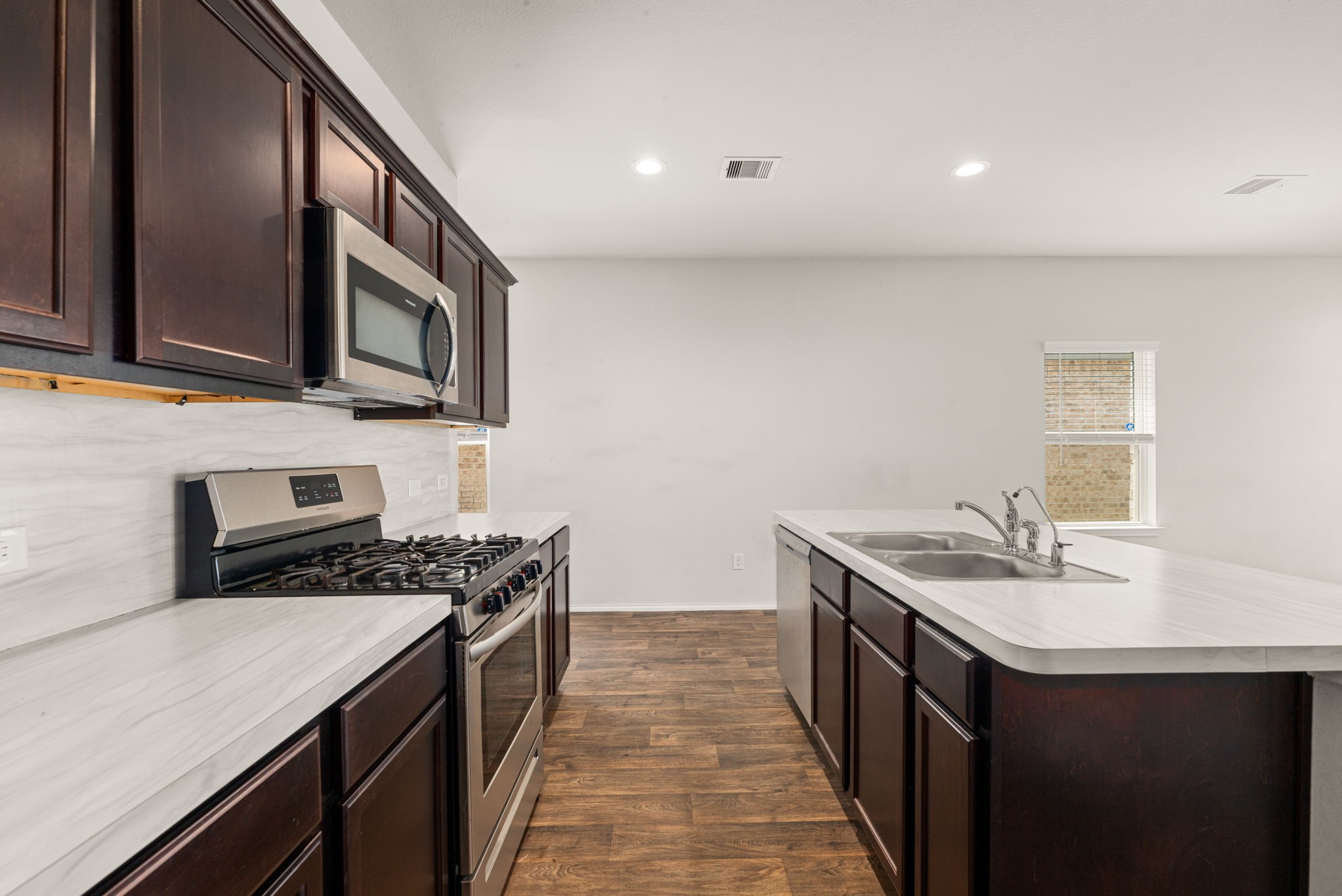23119 Rivercane Shadow Trail Spring, TX 77373 - Photo 6 of 32 a kitchen with stainless steel appliances granite countertop a sink stove and microwave