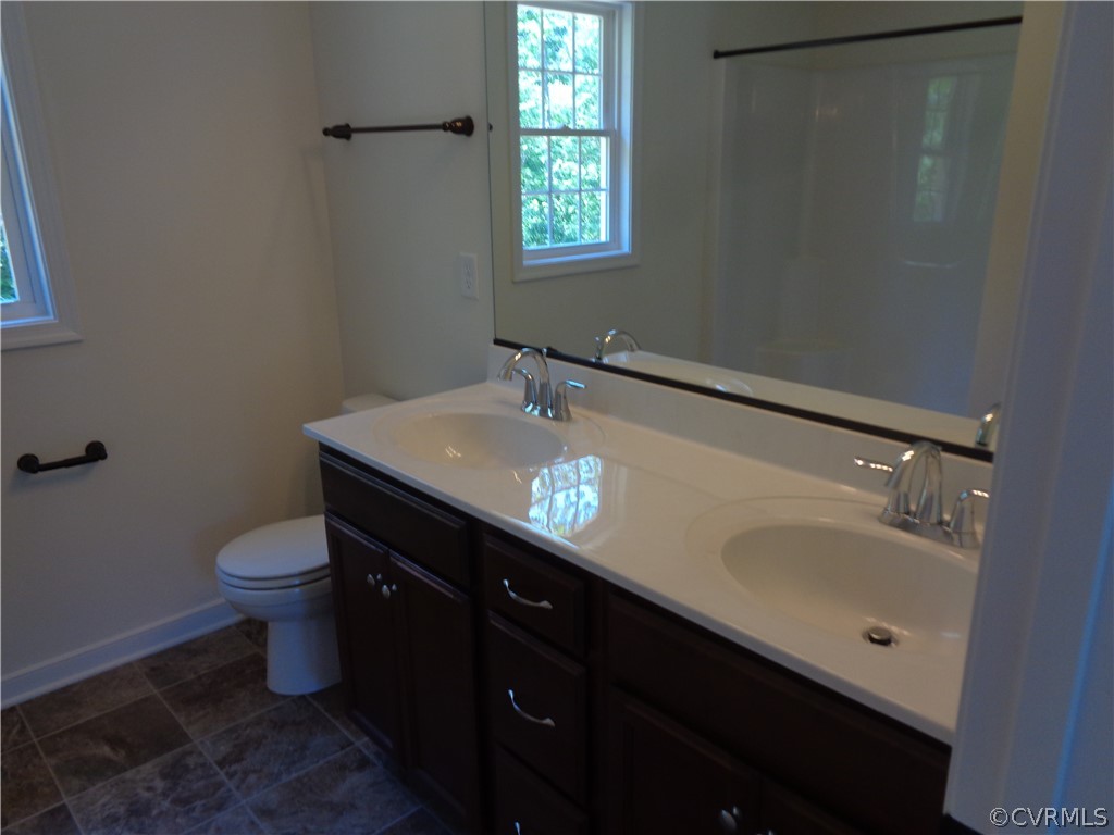 7112 Oakfork Loop New Kent, VA 23124 - Photo 11 of 21 a bathroom with a granite countertop sink toilet and a mirror