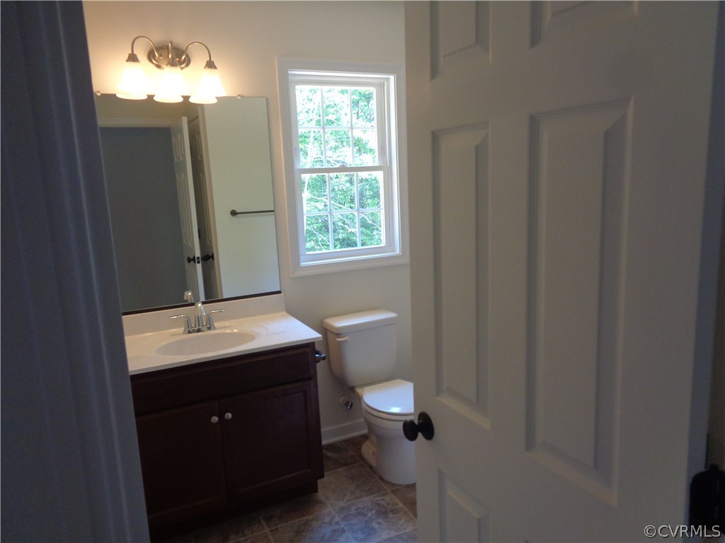 7112 Oakfork Loop New Kent, VA 23124 - Photo 13 of 21 a bathroom with a toilet sink and mirror
