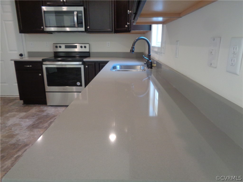 7112 Oakfork Loop New Kent, VA 23124 - Photo 6 of 21 a kitchen with stainless steel appliances a stove a microwave and a sink