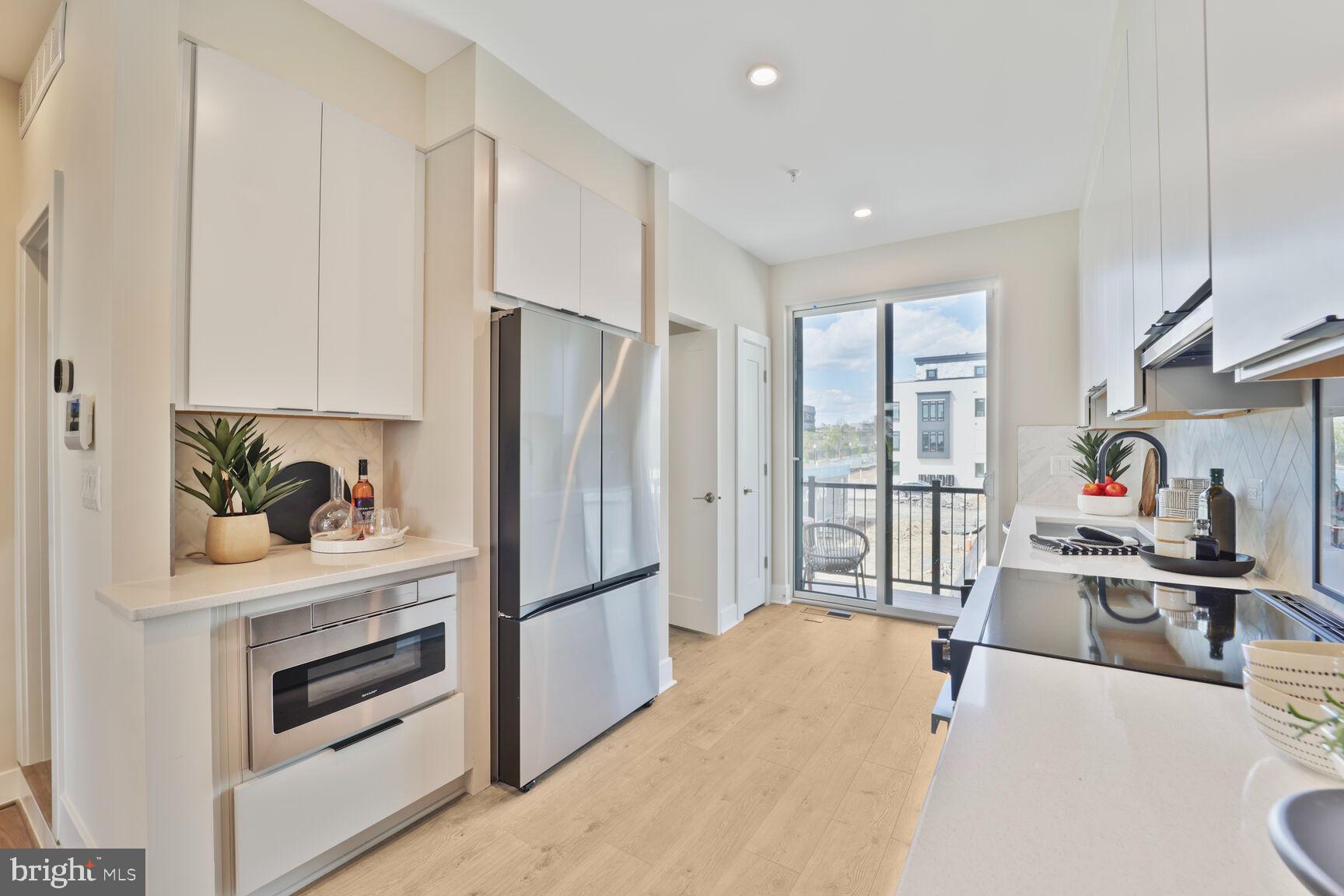 61 Lower Service Road Northwest, Unit ATWOOD 884 Washington, DC 20422 - Photo 8 of 21 a kitchen with stainless steel appliances a refrigerator and a stove top oven