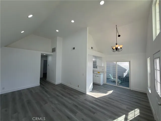 an empty room with wooden floor and entrance